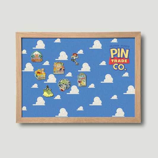 Wooden framed cork pin board with blue sky and clouds background and pin trade company text. Disney pins pinned onto the board.